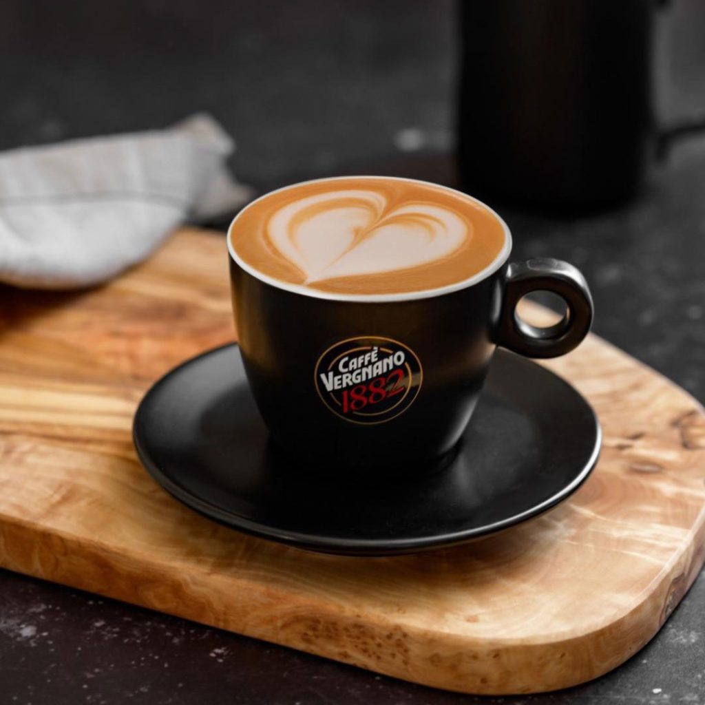 Tazza nera di caffé macchiato con logo Caffé Vergnano